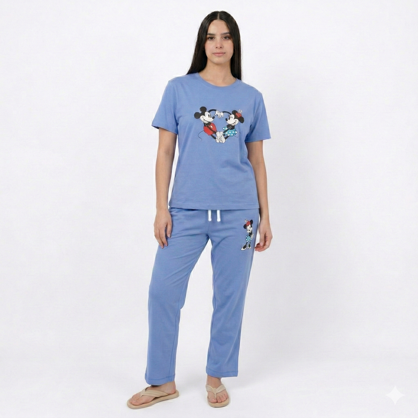 Woman wearing a blue pajama set with cartoon character design on a white background