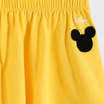 Yellow shorts with a black Mickey Mouse ears design and Disney logo on a white background