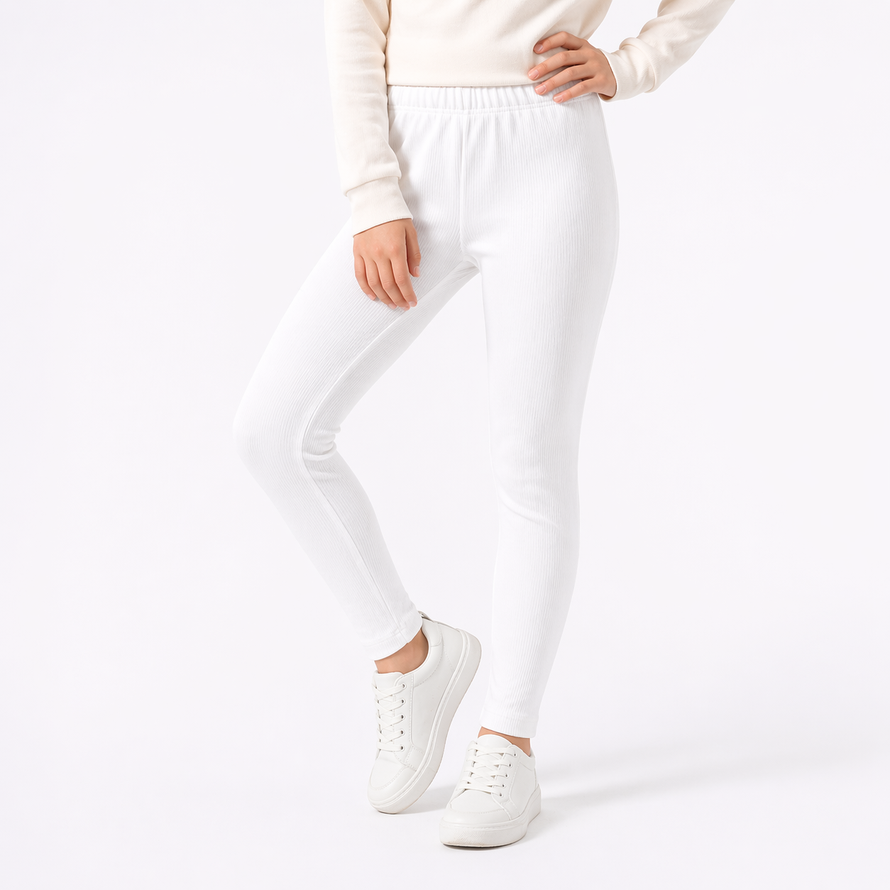 Person wearing white jogger pants and white sneakers on a white background
