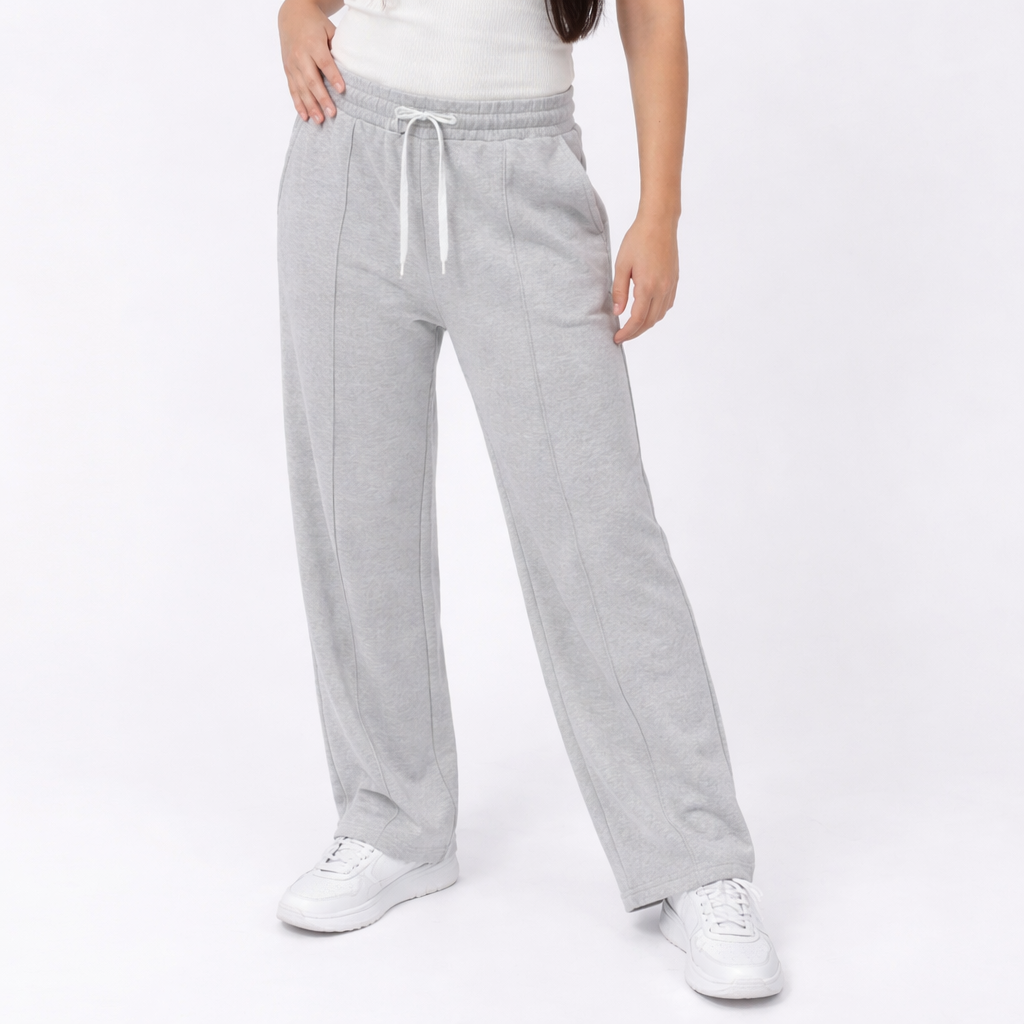 Person wearing gray sweatpants and white sneakers on a white background