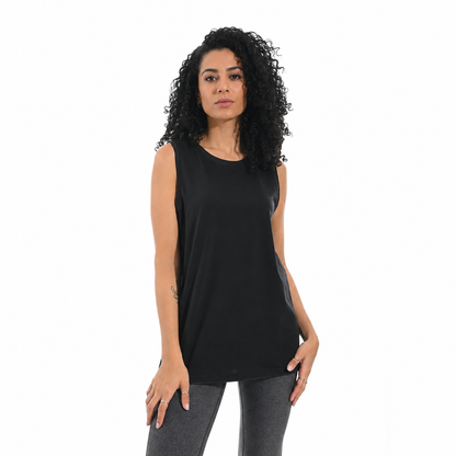 A woman with curly black hair wearing a black sleeveless tunic top and gray leggings, standing against a plain white background.