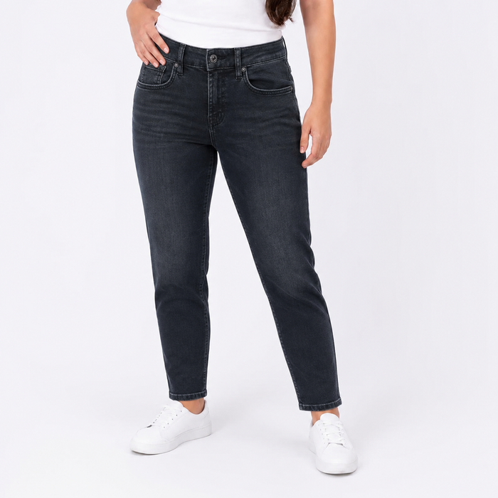 A model wearing a pair of dark wash slim-fit jeans with a white t-shirt and white sneakers, shown from the waist down against a plain white studio background.