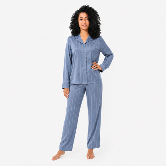 Woman wearing a blue striped pajama set on a white background