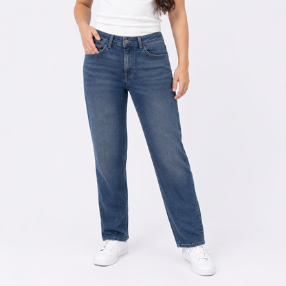Person wearing blue jeans and white sneakers on a white background