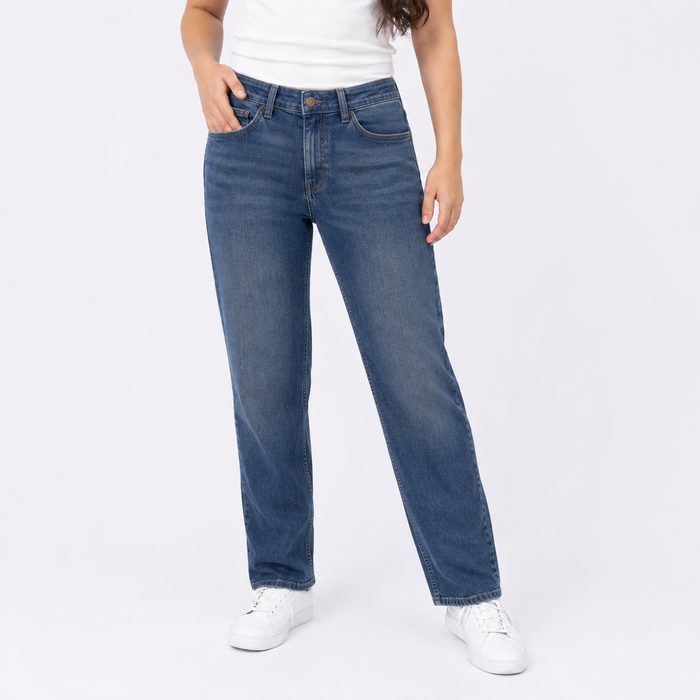 Person wearing blue jeans and white sneakers on a white background