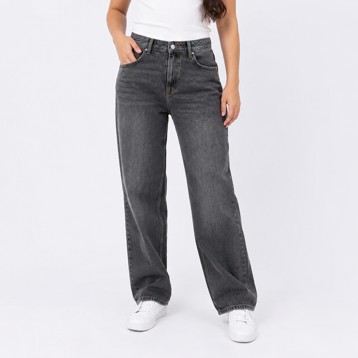 Person wearing black jeans and white sneakers on a white background