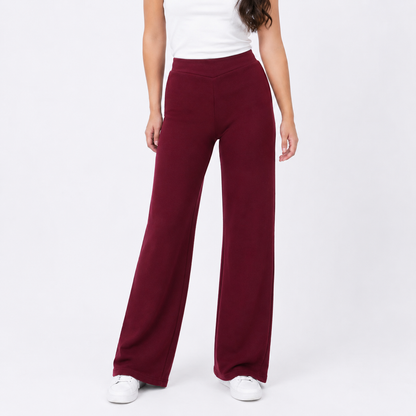 Person wearing burgundy wide-leg pants on a white background
