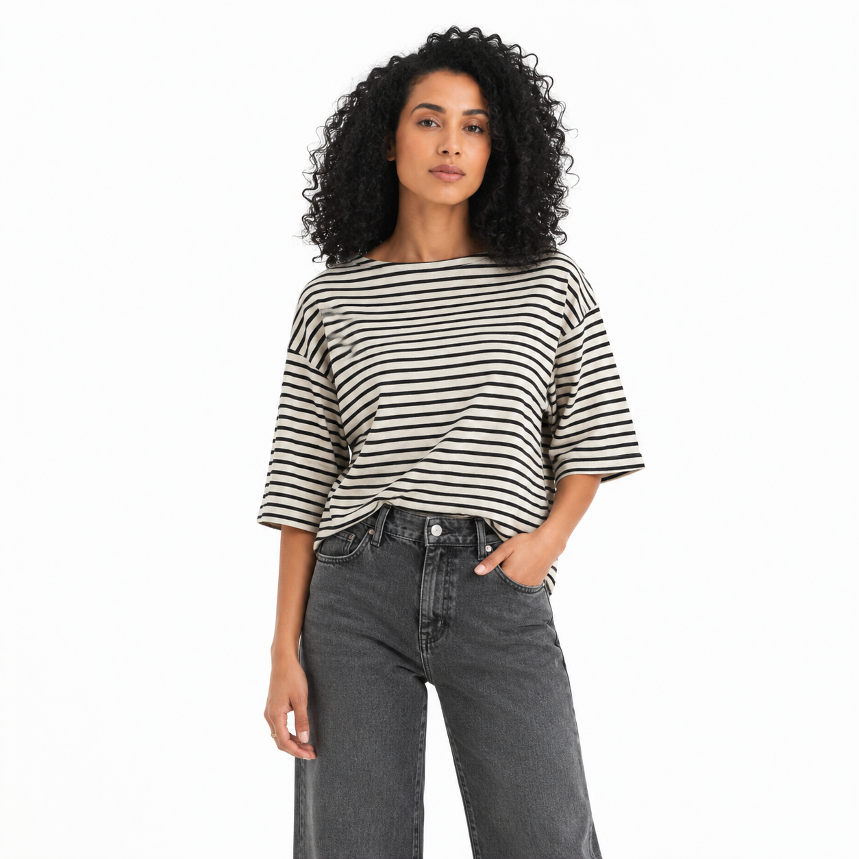 Woman wearing a black and white striped shirt and gray jeans on a white background