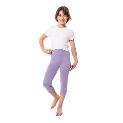 A young girl modeling a white short-sleeve t-shirt and lavender purple cropped leggings against a plain white background.