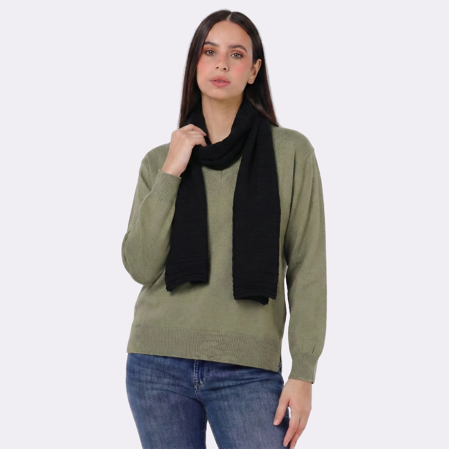 Woman wearing a green sweater and black scarf on a white background