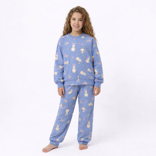 Child wearing a blue pajama set with animal prints on a white background