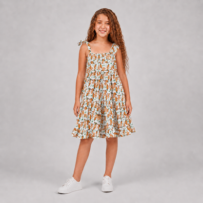 Girl wearing white bunny print tiered dress with asymmetric shoulder details